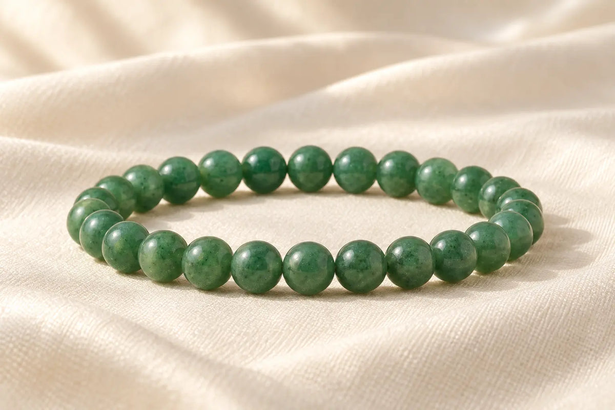Nityara Number 5 Green Aventurine bracelet showing natural green bead variation on ivory fabric