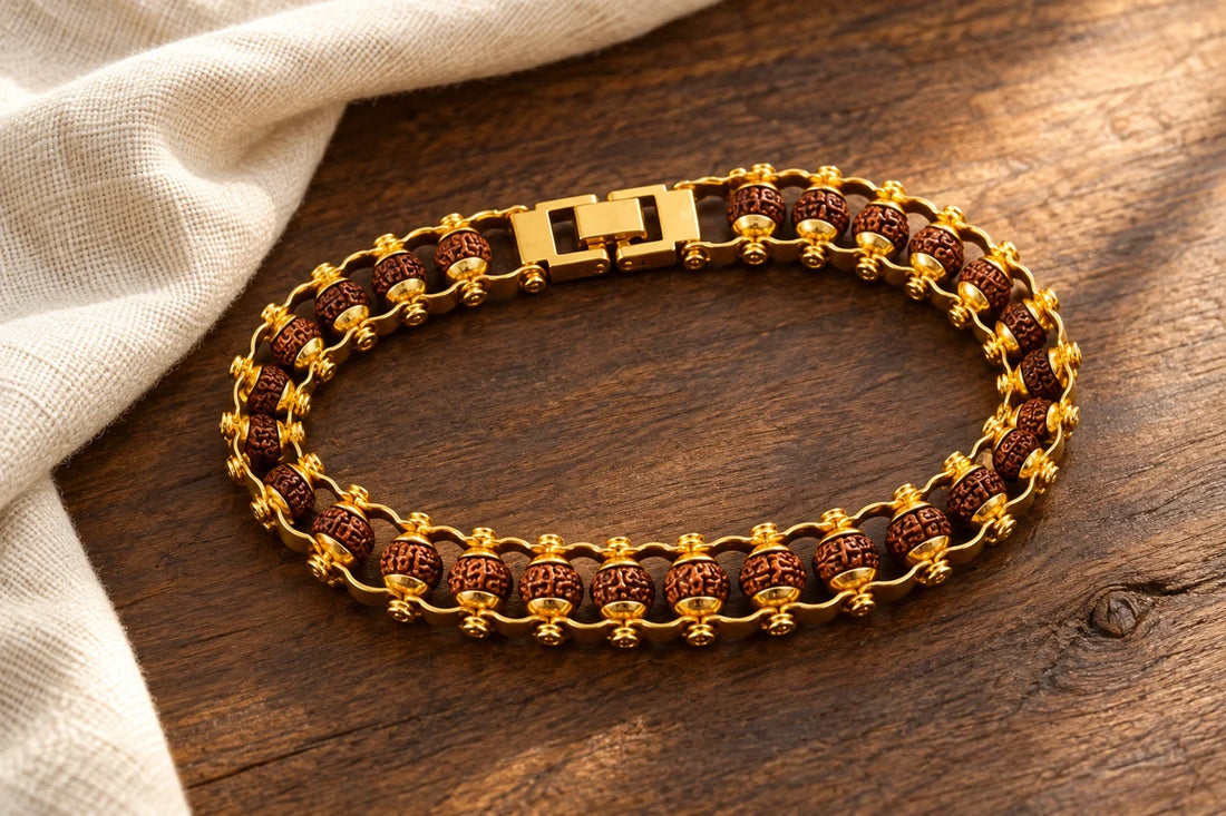 Editorial illustration of Nityara’s gold-tone linked Rudraksha bracelet with a rectangular clasp on wood.